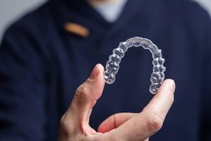 Man holding one transparent aligner