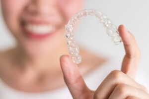 Smiling girl with invisalign wearing white shirt