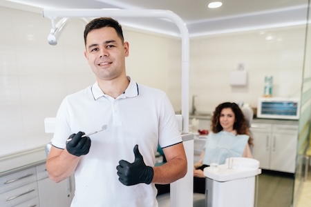 A dentist at his dental clinic getting ready for the dental examination of his patient.