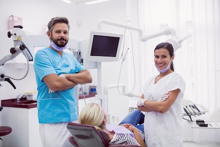 A male and a female dentist standing at their dental clinic.