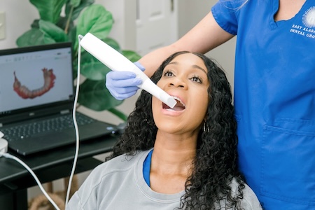 A female patient is getting laser gingivitis treatment at the dental office.