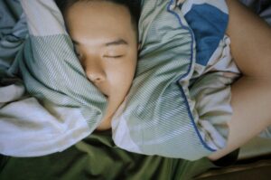 Person sleeping under cozy striped blanket