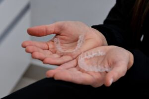 Hands holding clear dental aligners