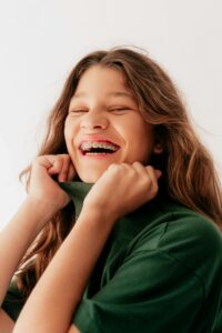 Smiling girl with braces in green shirt