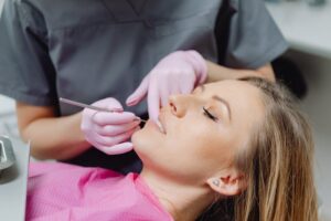 Woman receiving dental check-up wearing pink bib