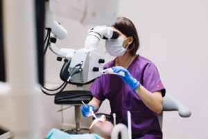Dentist performing procedure with microscope tool