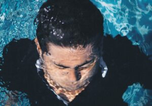Man submerged underwater in blue pool