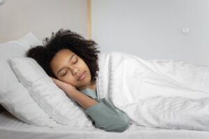 Person sleeping peacefully in white bed