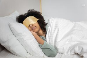 Person sleeping with eye mask in bed